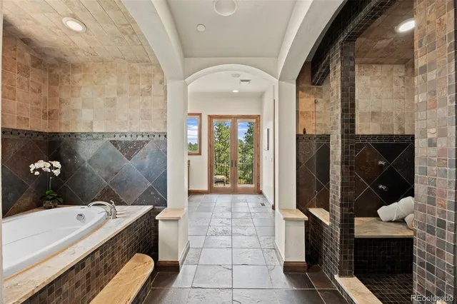 a bathroom with a tub sink and mirror
