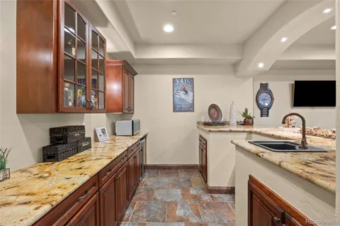 a spacious bedroom with a bed a dresser and a chandelier