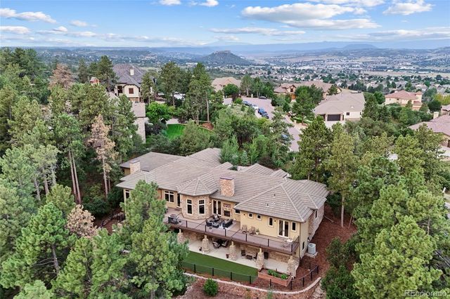 an aerial view of a house with swimming pool and furniture
