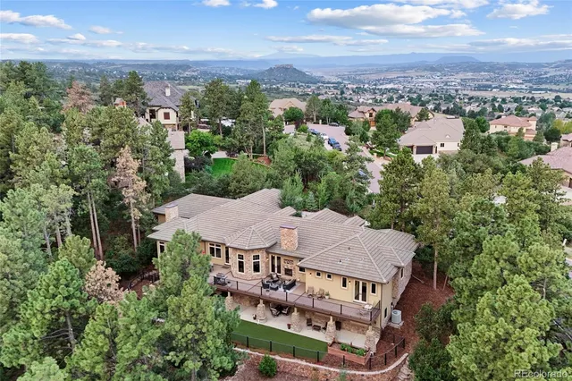 an aerial view of a house with swimming pool and furniture