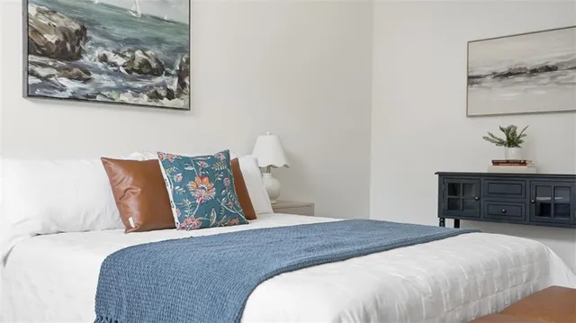 a bedroom with bed and painting on the wall