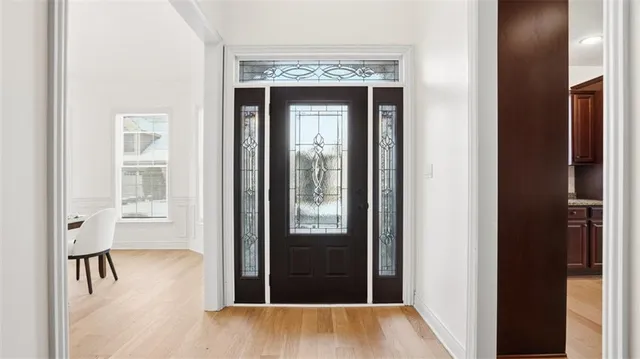 a view of a hallway with wooden floor and a chandelier
