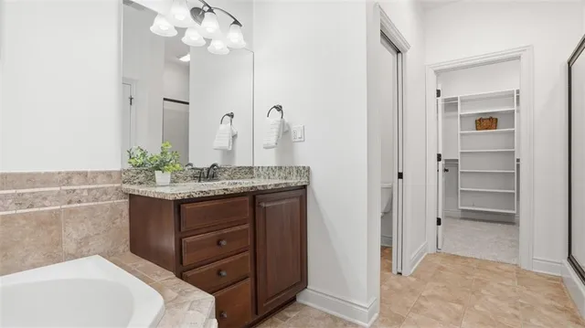 a bathroom with a granite countertop sink a mirror and a vanity