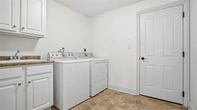 a utility room with cabinets washer and dryer