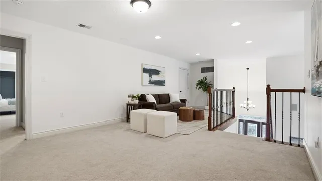a living room with furniture a large window and a potted plant