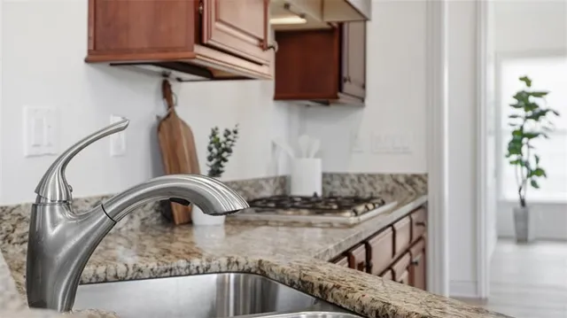 a kitchen with a granite countertop sink a stove and a microwave