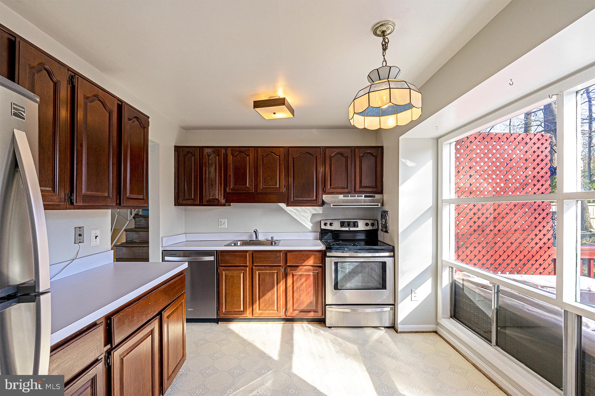 8207 Old Oaks Drive Springfield, VA 22152 - Photo 7 of 19 a kitchen with stainless steel appliances granite countertop a stove a sink and a refrigerator