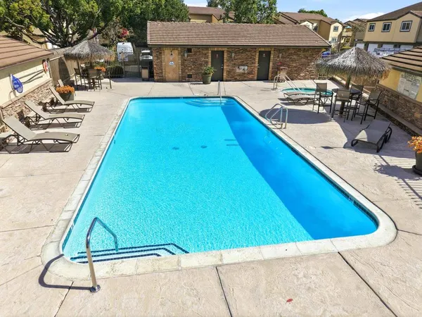a swimming pool with outdoor seating and yard