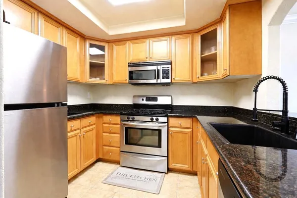 a kitchen with stainless steel appliances granite countertop a stove a sink and a microwave