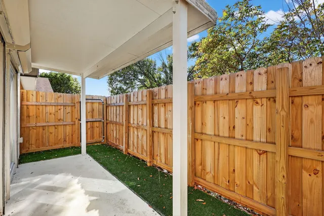 a view of a house with a small yard and wooden fence