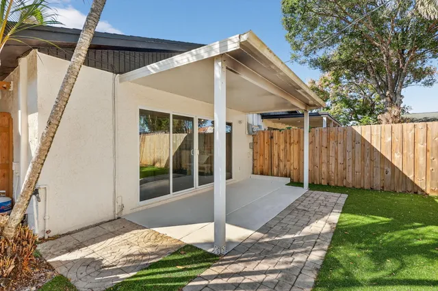 a view of house with backyard and glass windows
