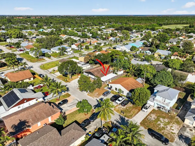 an aerial view of residential house with outdoor space and trees
