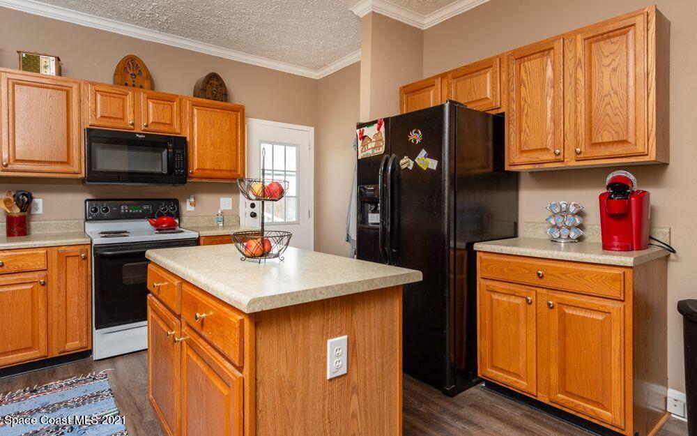 1817 Jones Road Melbourne, FL 32934 - Photo 22 of 38 a kitchen with stainless steel appliances granite countertop a refrigerator stove microwave and sink