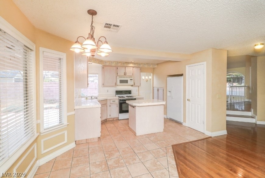 1429 Hawkwood Road Henderson, NV 89014 - Photo 12 of 53 Tiled flooring and wood transitions define this functional kitchen layout with dual dining areas.