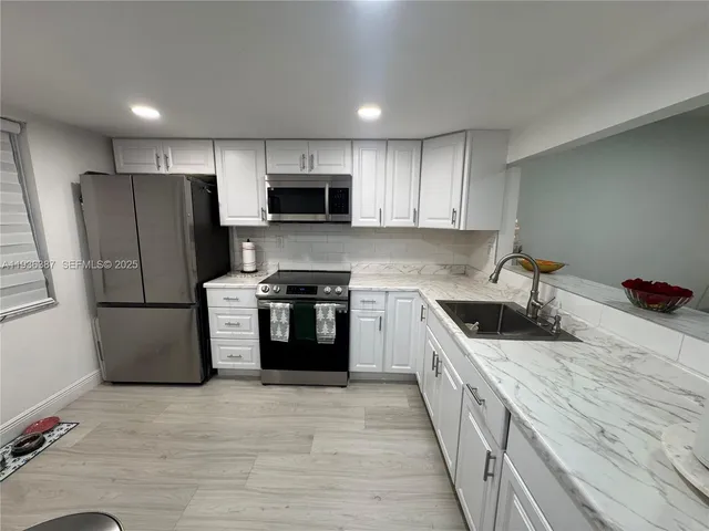 a kitchen with a refrigerator a stove top oven a sink and dishwasher