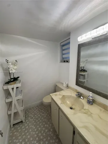 a bathroom with a sink toilet and mirror