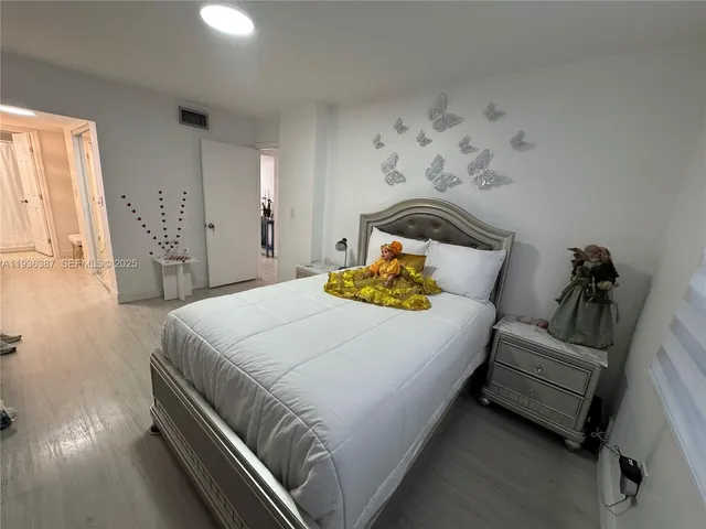 a bedroom with bed and wooden floor