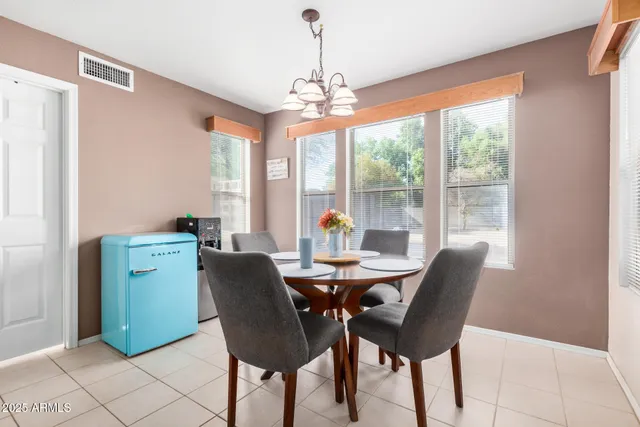 a dining room with furniture a chandelier and wooden floor