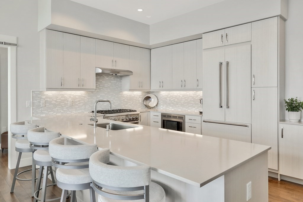 10 Shipyard Drive, Unit 510 Hingham, MA 02043 - Photo 15 of 40 a kitchen with stainless steel appliances a stove a table and chairs