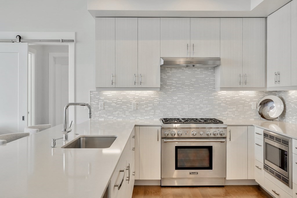 10 Shipyard Drive, Unit 510 Hingham, MA 02043 - Photo 16 of 40 a kitchen with granite countertop white cabinets and stainless steel appliances