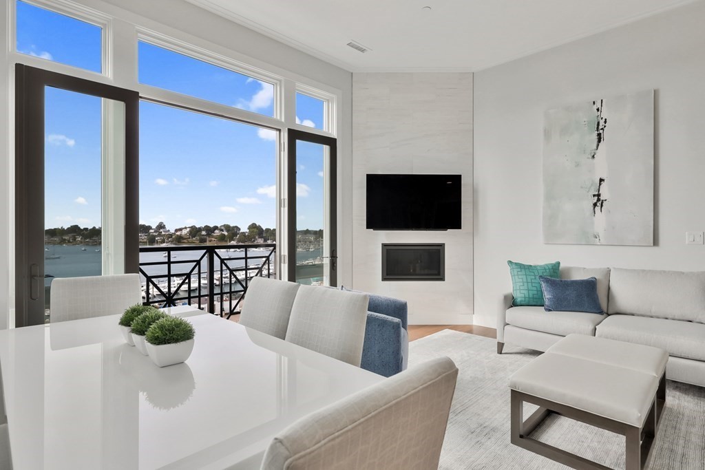 10 Shipyard Drive, Unit 510 Hingham, MA 02043 - Photo 3 of 40 a living room with furniture a flat screen tv and a floor to ceiling window