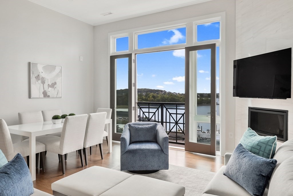 10 Shipyard Drive, Unit 510 Hingham, MA 02043 - Photo 4 of 40 a living room with furniture a flat screen tv and a floor to ceiling window