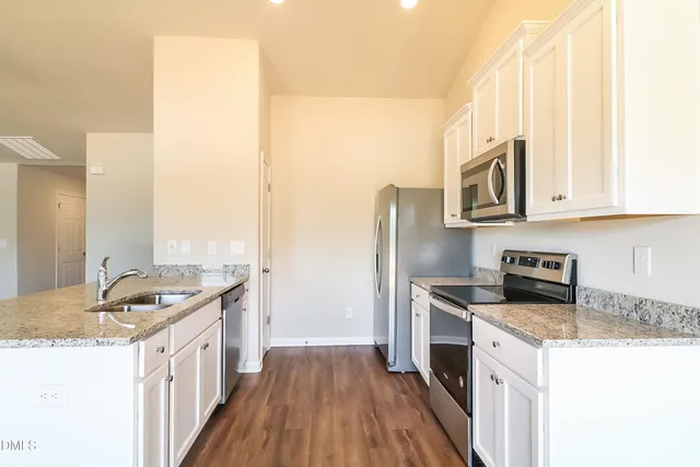 a kitchen with stainless steel appliances granite countertop a stove a sink and a microwave