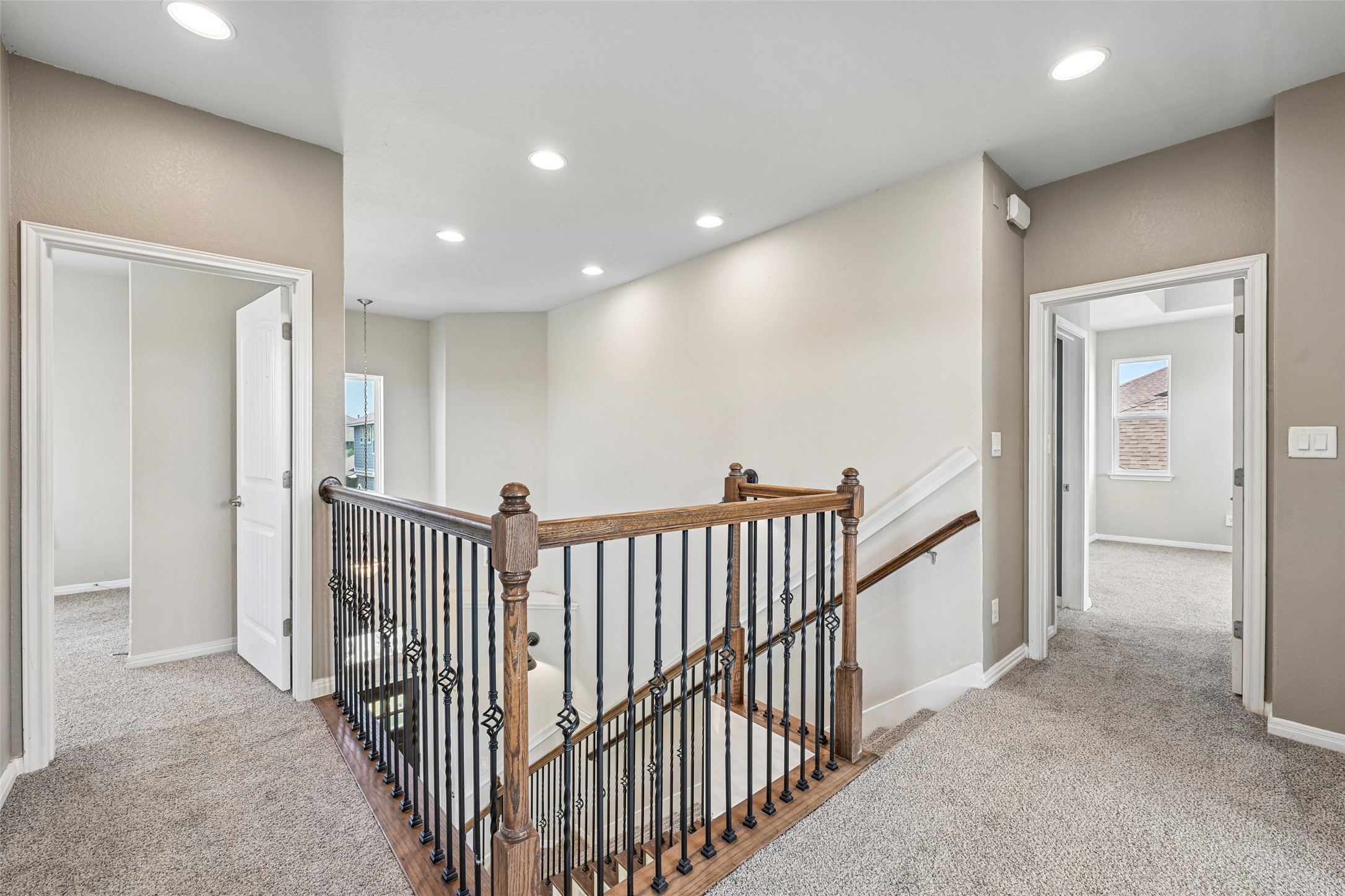 1297 Harwell Loop Kyle, TX 78640 - Photo 24 of 39 Recessed lighting illuminates the carpeted upper landing, complete with an elegant wood and wrought iron staircase.