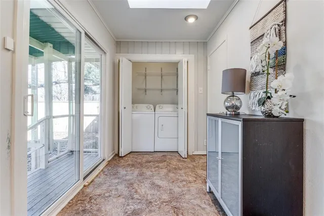 a view of a room that has a large window and wooden floor