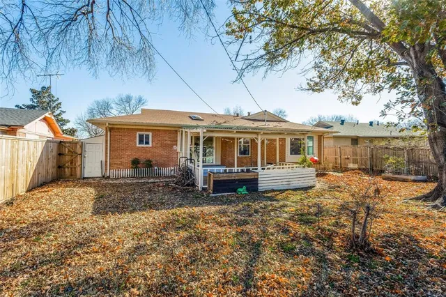 a front view of a house with a yard covered with trees