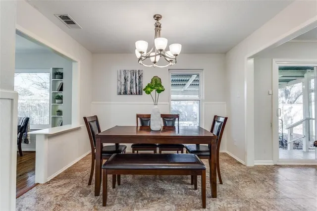 a view of a dining room with furniture a chandelier and wooden floor