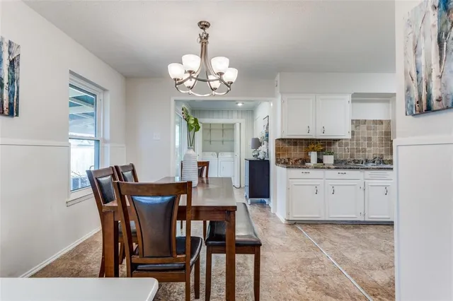 a view of a dining room with furniture a chandelier and wooden floor