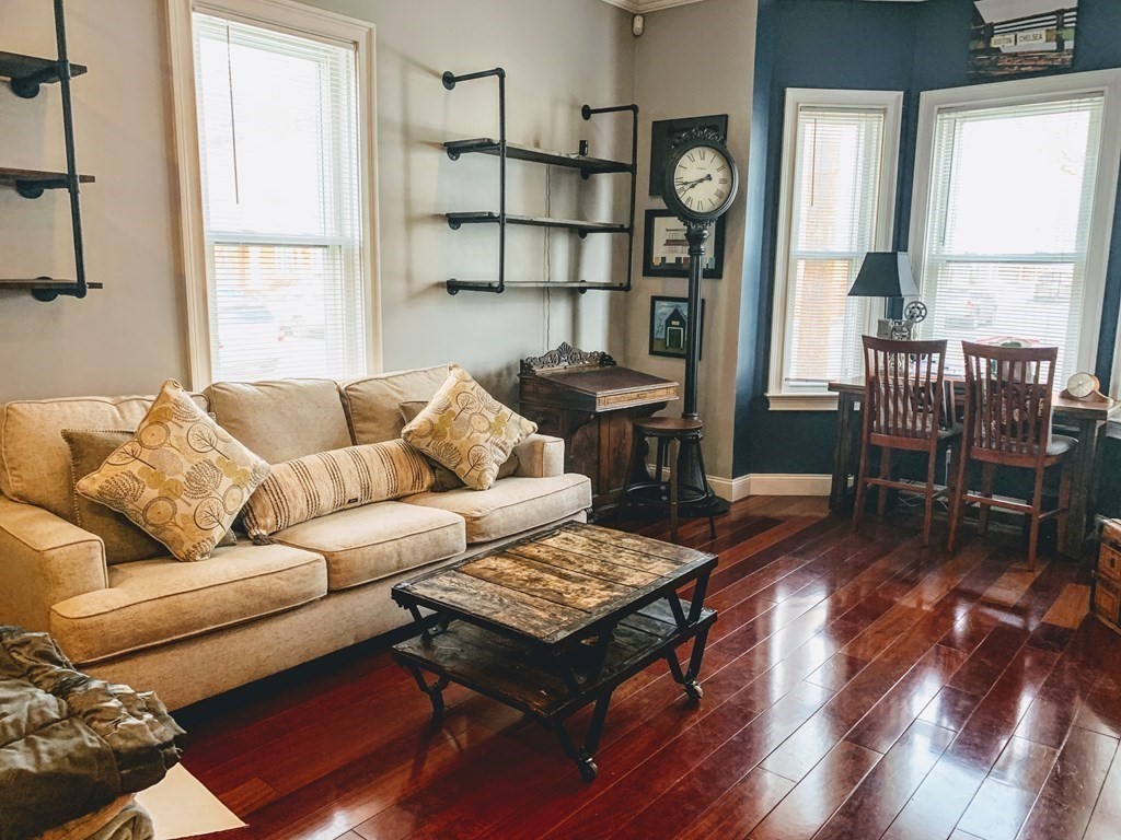 a living room with furniture a window and wooden floor