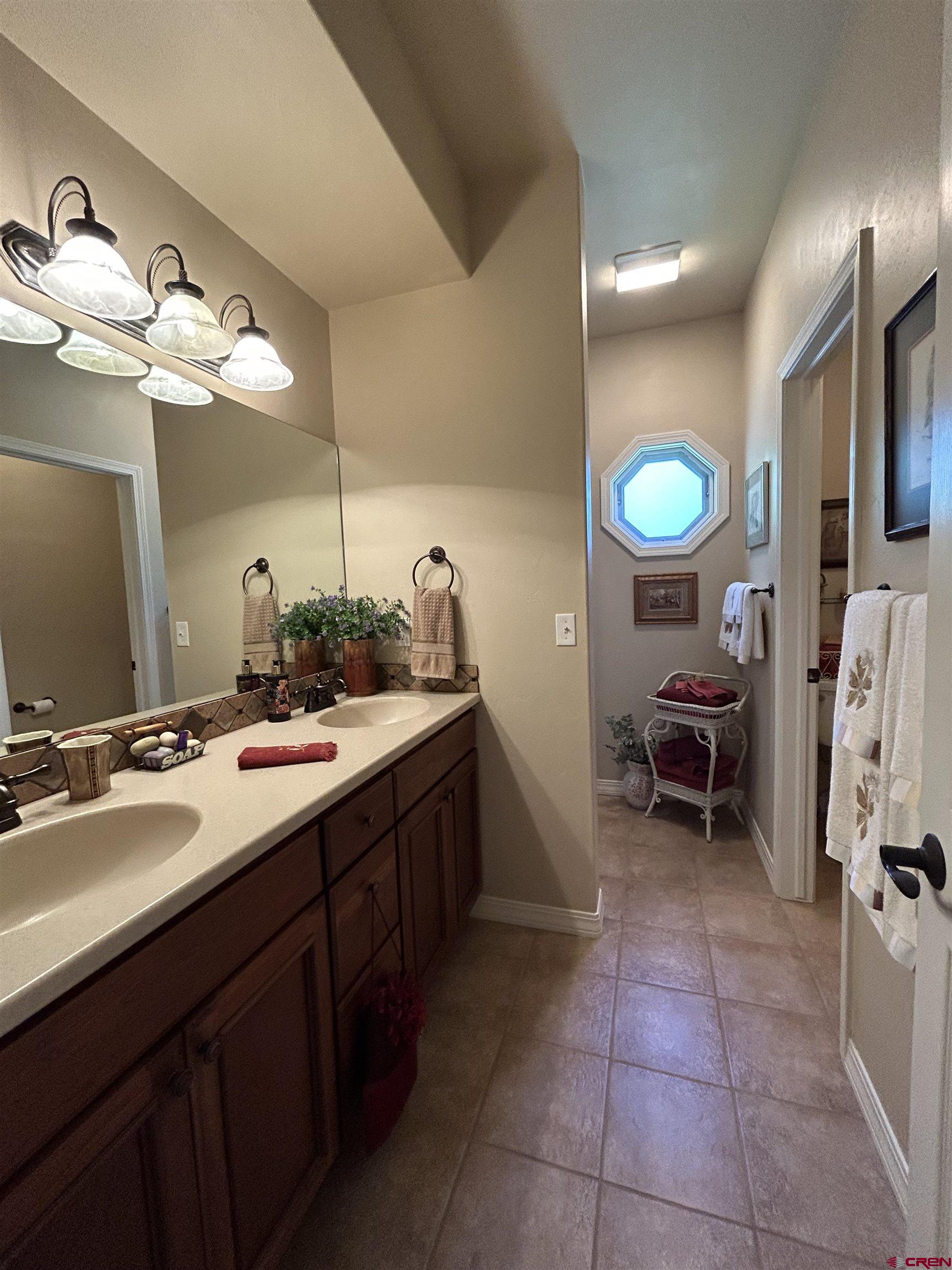 850 Southeast Pinyon Street Cedaredge, CO 81413 - Photo 26 of 45 a spacious bathroom with a double vanity sink and a mirror