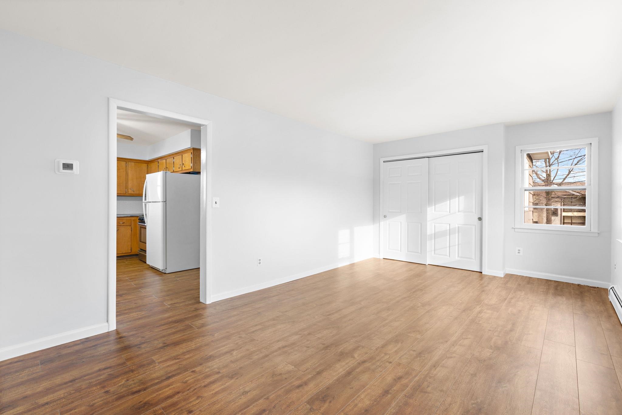 70 2nd Avenue, Unit 2 Secaucus, NJ 07094 - Photo 2 of 14 a view of an empty room with wooden floor and a window