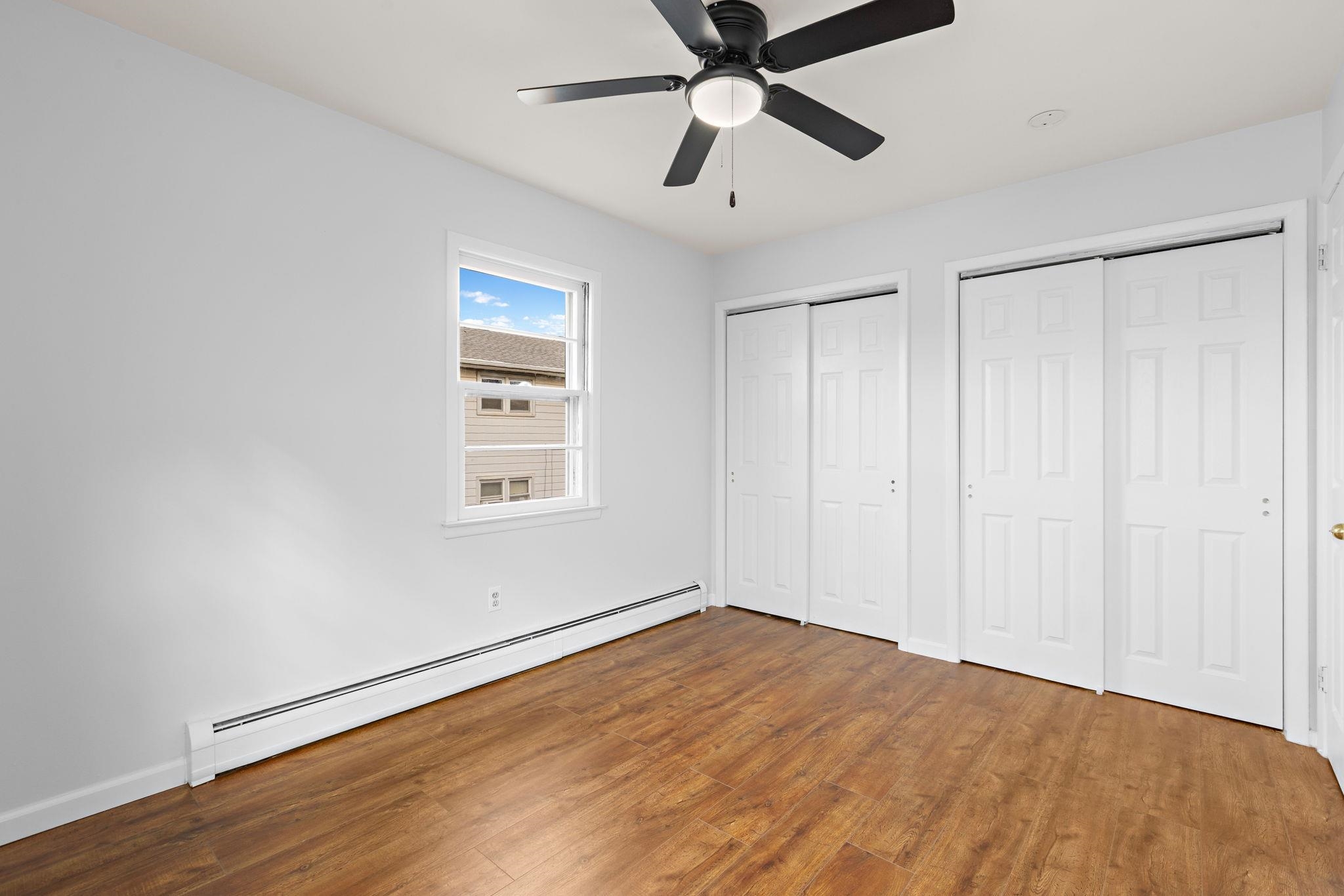 70 2nd Avenue, Unit 2 Secaucus, NJ 07094 - Photo 8 of 14 an empty room with wooden floor closet and fan