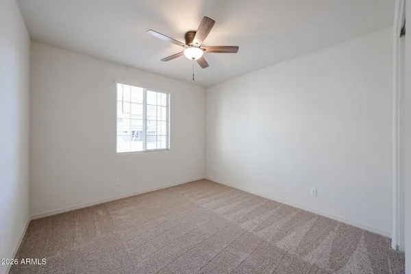 an empty room with a window and a fan