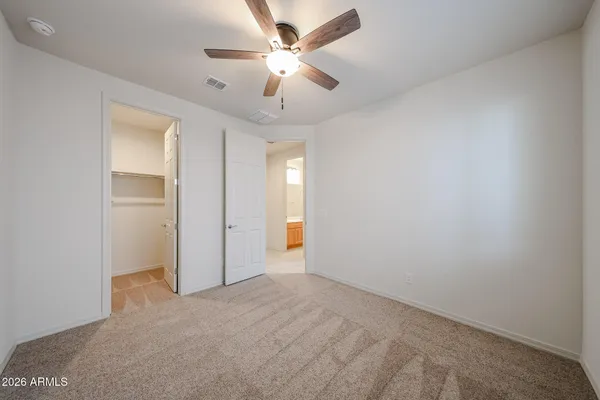 an empty room with ceiling fan and window