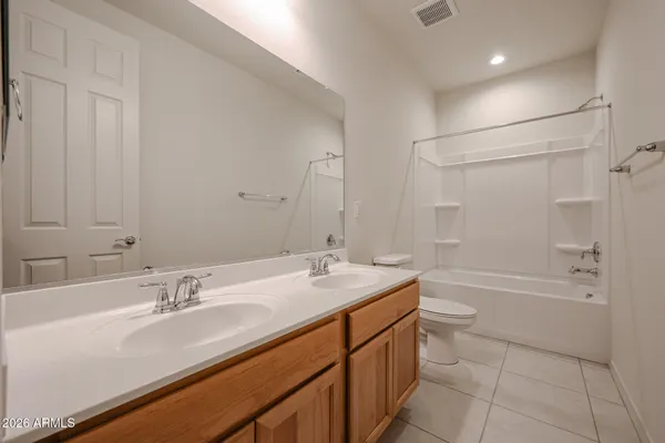 a bathroom with a granite countertop sink mirror toilet and bathtub