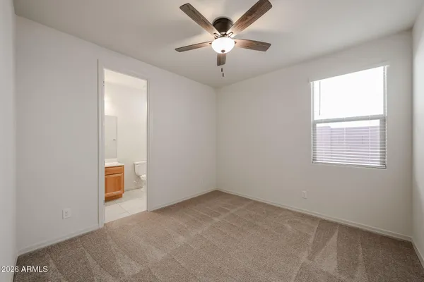 an empty room with a window and a fan