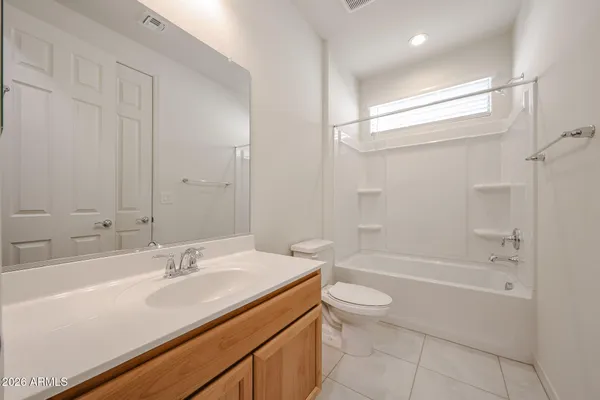 a bathroom with a granite countertop sink a toilet and bathtub