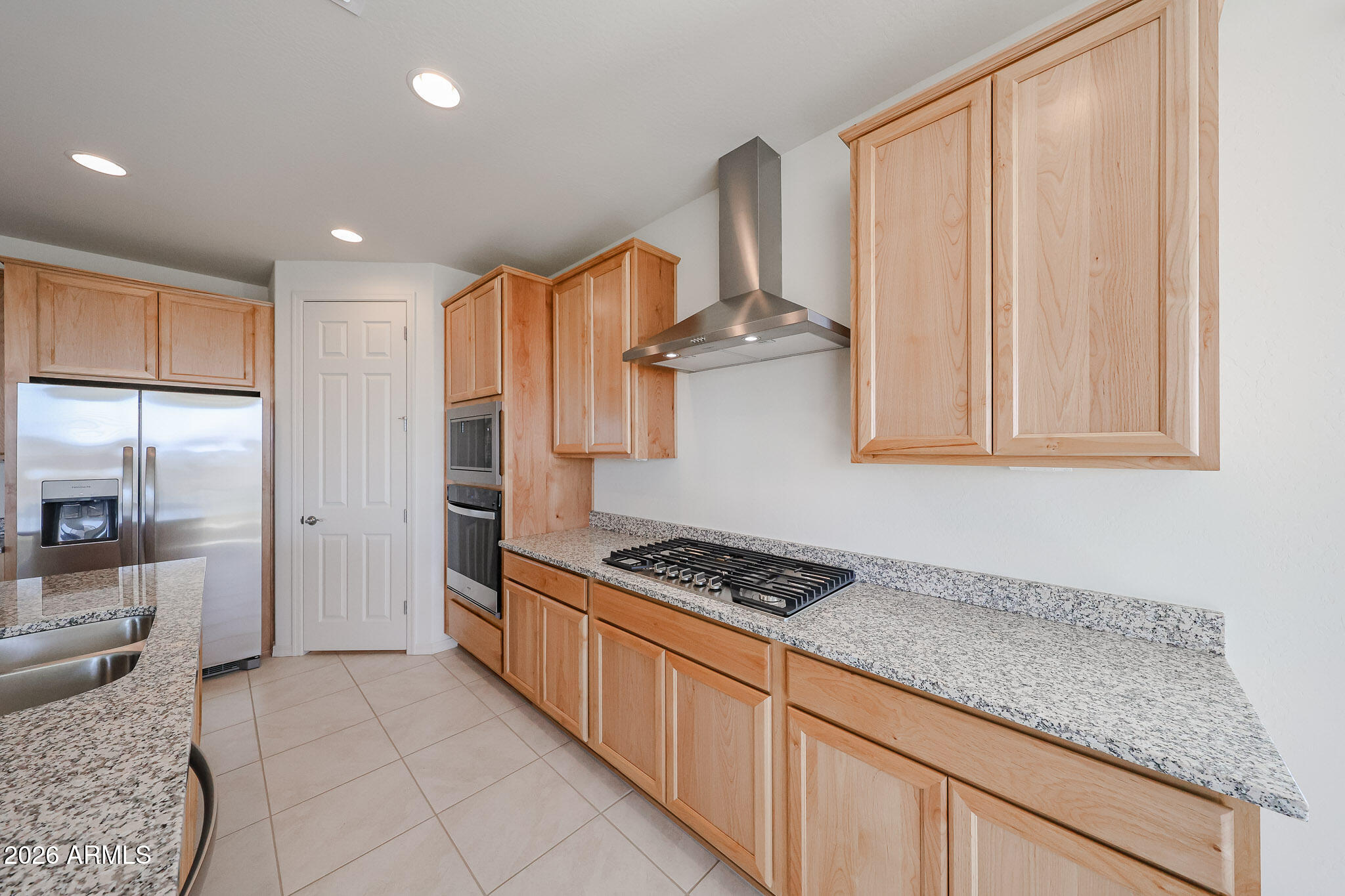 7023 West Plum Road Peoria, AZ 85383 - Photo 3 of 22 a kitchen with stainless steel appliances granite countertop a stove a sink and a refrigerator