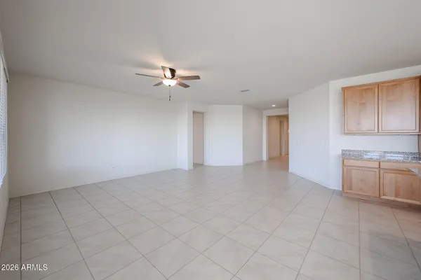 a view of an empty room with a ceiling fan and a window