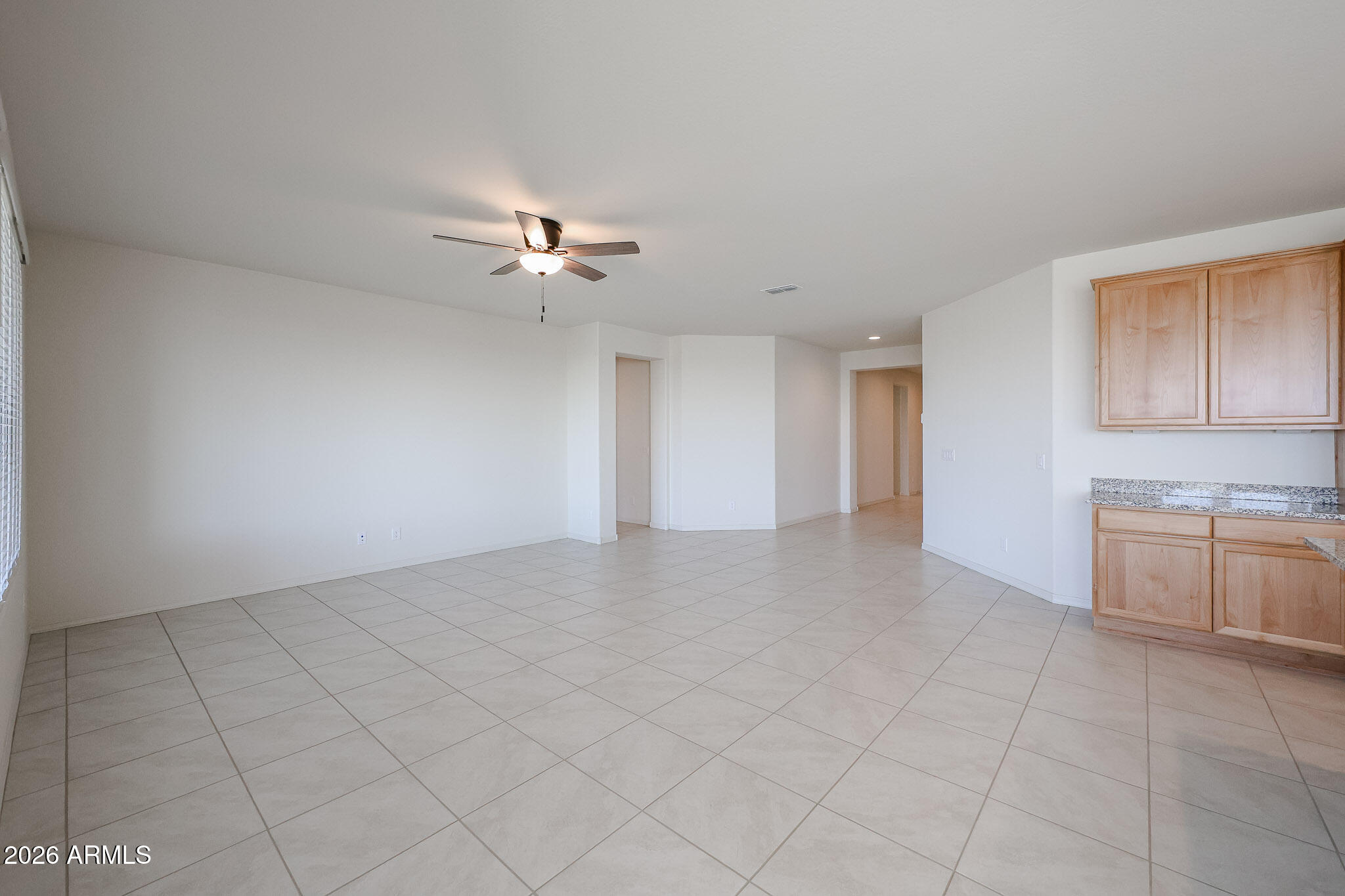 7023 West Plum Road Peoria, AZ 85383 - Photo 7 of 22 a view of an empty room with a ceiling fan and a window