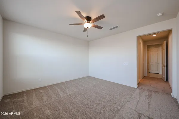 an empty room with closet and ceiling fan