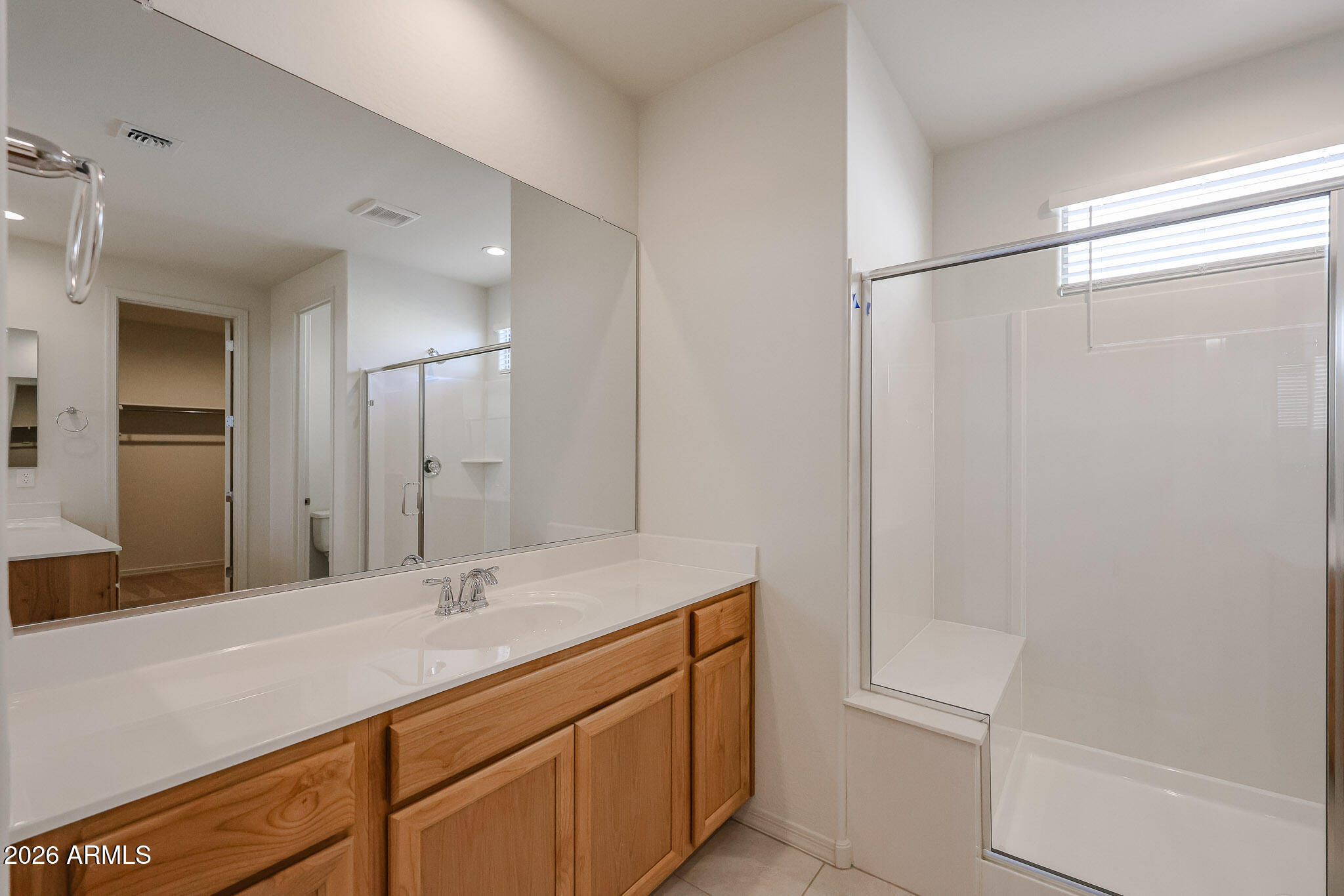 7023 West Plum Road Peoria, AZ 85383 - Photo 10 of 22 a bathroom with a shower sink vanity and mirror