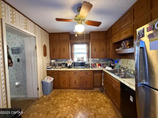 a kitchen with stainless steel appliances granite countertop sink stove and refrigerator