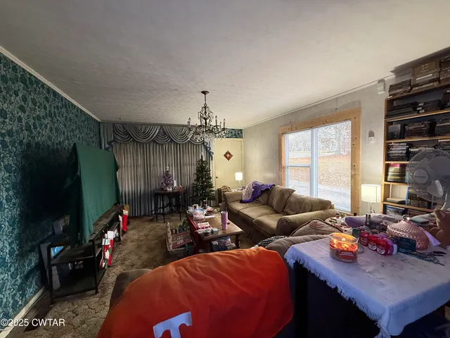 a living room with furniture a flat screen tv and a large window