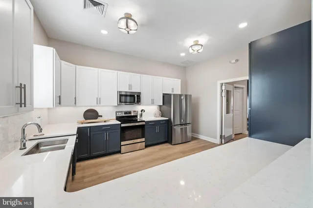 a kitchen with stainless steel appliances granite countertop a sink refrigerator stove and microwave