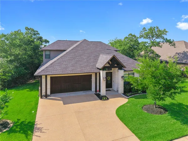a front view of a house with yard and green space